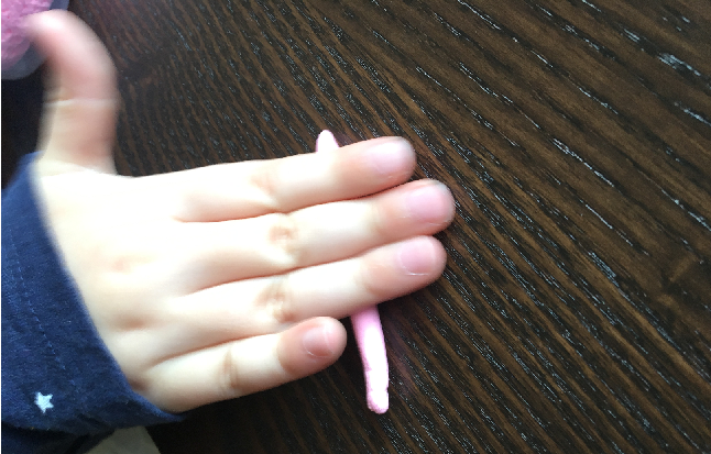 Kinderhand rollt ein Knetwürstchen