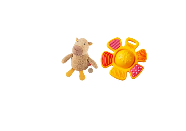 Sigikid-Spieluhr in Form eines Capybaras und ein bunter HABA-Greifling in Blumenform