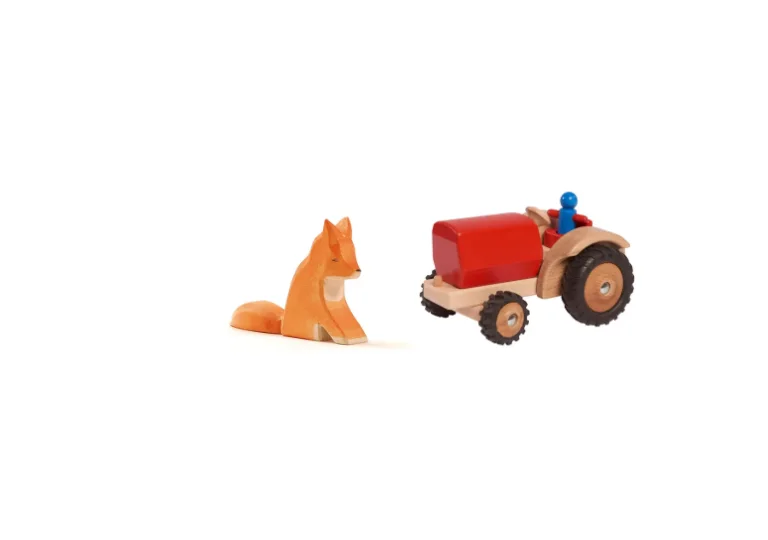 Holzspielzeug: ein sitzender Fuchs von Ostheimer und ein roter Holztraktor mit Fahrerfigur