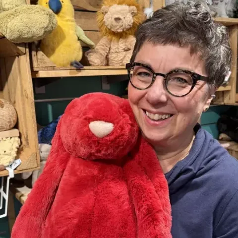 Mitarbeiterin von Salima mit einem großen roten Jellycat-Hasen